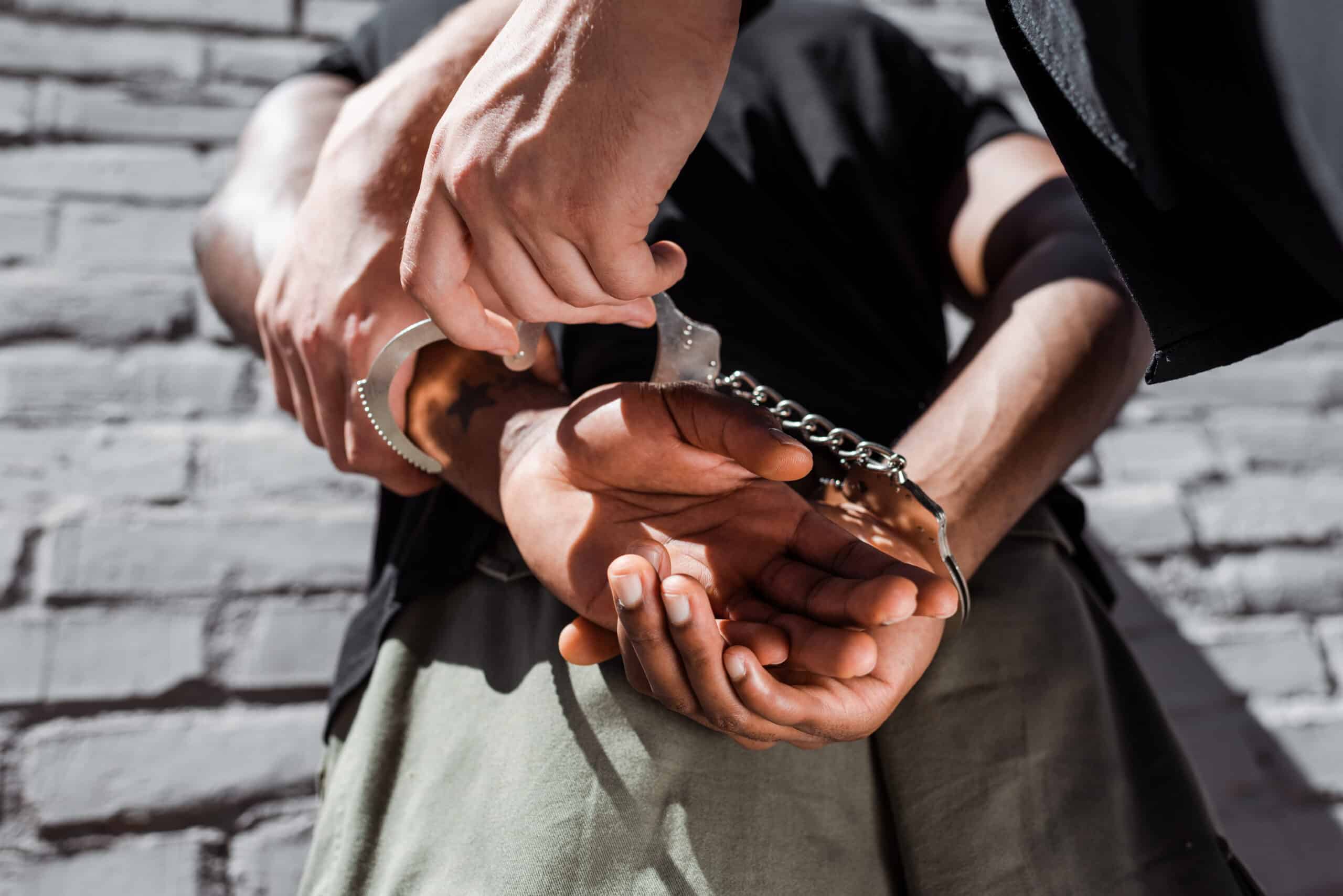 Person with handcuffs being placed on